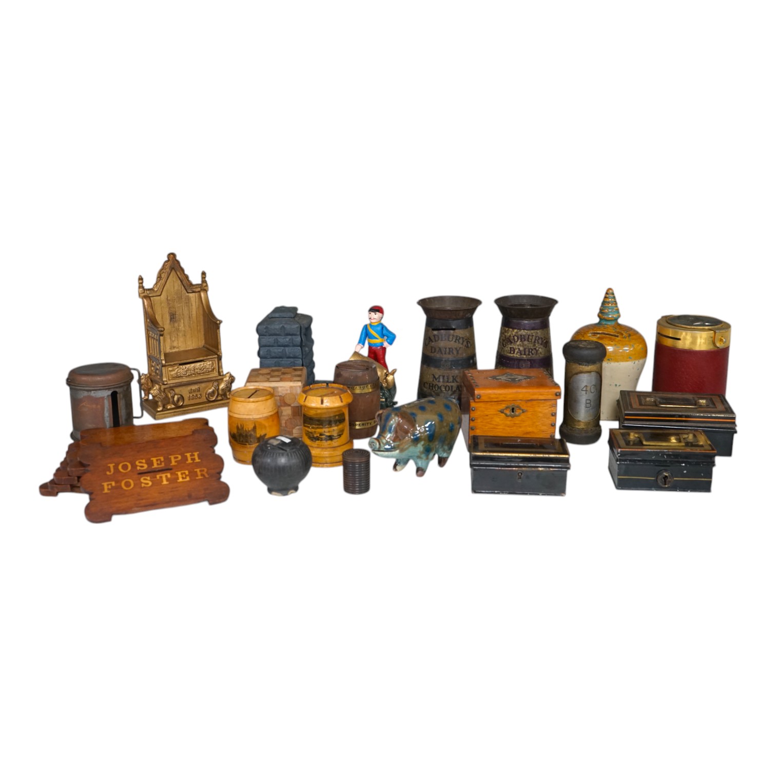 A collection of mixed tin wood and ceramic money boxes to include Cadbury’s milk chocolate, three in the form of trunks and a ceramic pig. Condition - varies